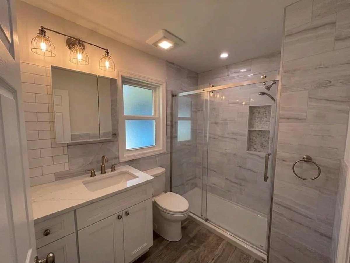 Bright Long Island bathroom renovation with white vanity and walk-in tile shower - Best In Class Renovations